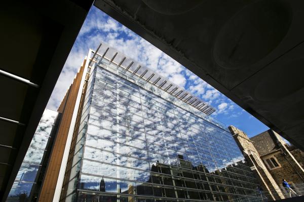 Glass exterior of Brodhead Center with blue sky and clouds reflecting in the windows