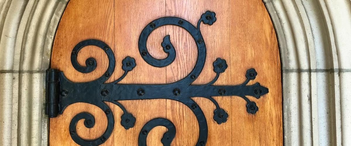 Image of wooden door with iron scroll decoration