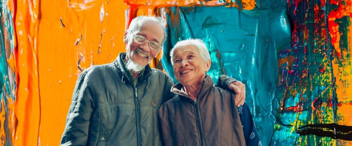 Smiling older man and woman with colorful background